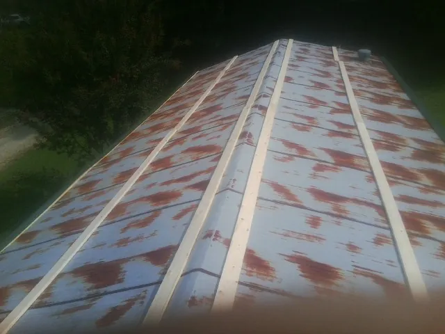 Rusted metal roof panels with new wood purlins before replacement — Storm Damage Roof Repair in Cerro Gordo by Roofing Brothers